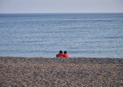 2 girls hugging on pebble beach