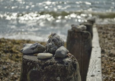 Large pebbles on wood by sea